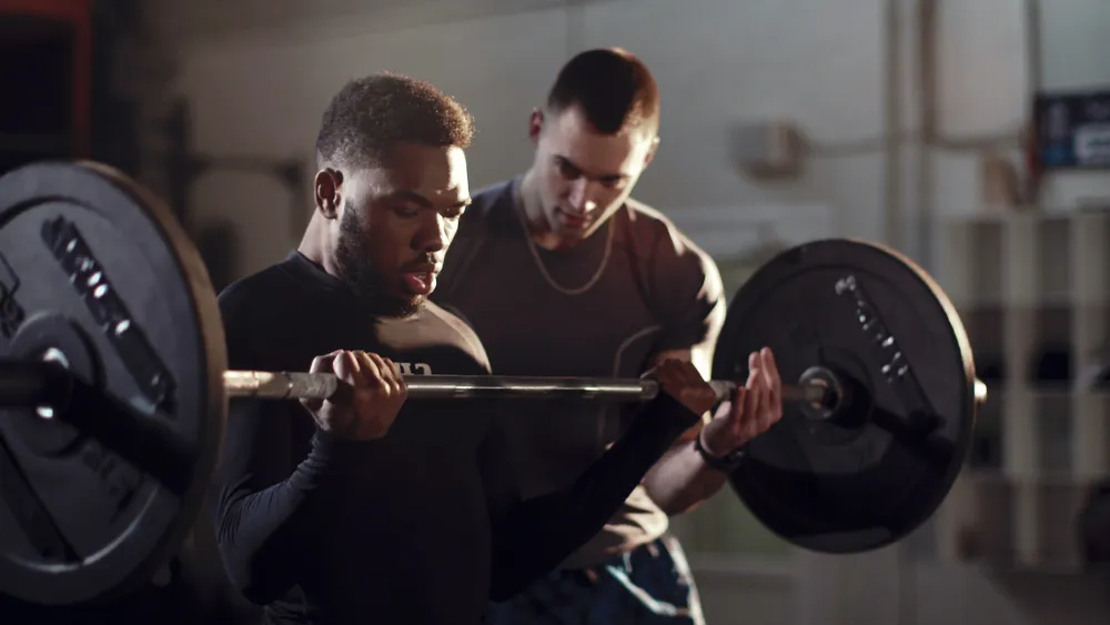 Man working out with trainer intensely